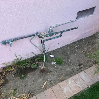 A + Electric & Plumbing - Professional outdoor water pipe installation on pink stucco wall. Reliable plumbing services! - Plumbing Near Me - Tujunga, California