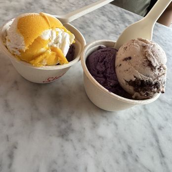 Stella Jean’s Ice Cream - Left: split single with mango sticky rice and ube pandesal toffee Right: split single with ube pandesal toffee and milk & cookies - Ice Cream & Frozen Yogurt Near Me - Costa Mesa, California Stella Jean’s Ice Cream - Left: split single with mango sticky rice and ube pandesal toffee Right: split single with ube pandesal toffee and milk & cookies - Ice Cream & Frozen Yogurt Near Me - Costa Mesa, California