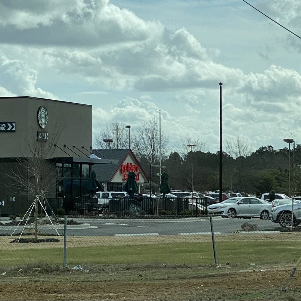 cars parked in front of a starbucks coffee shop