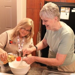 Caring Senior Service caregiver helping a client bake a cake