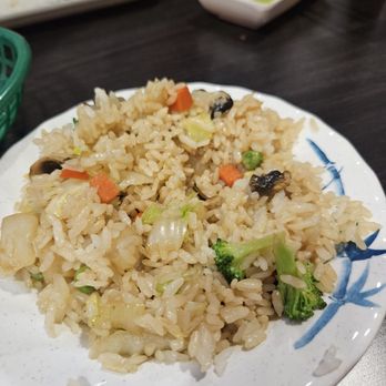 Sakura Sushi - Veggie fried rice - A serving of veggie fried rice on a white plate, containing broccoli, carrots, mushrooms, and rice, served in a restaurant setting. - Salad Near Me - Gilbert, Arizona