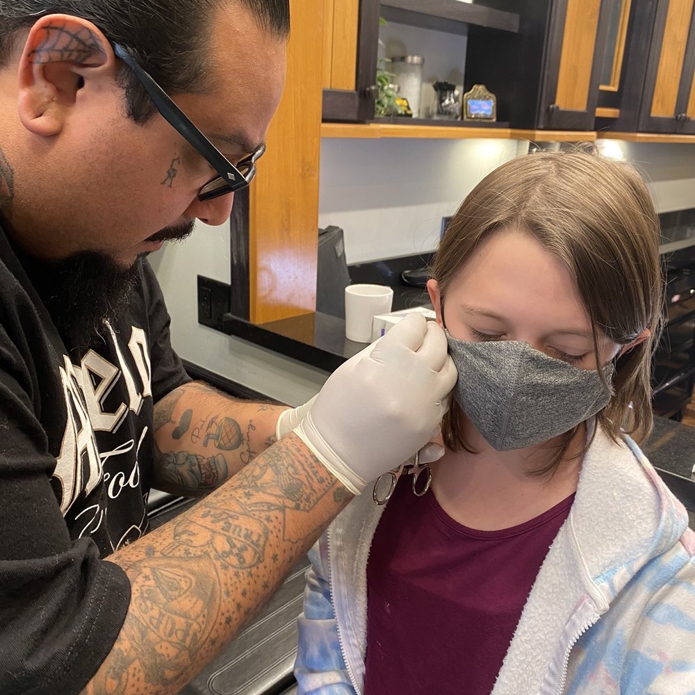 Maritime Tattoo - Piercer doing earlobe piercing - Tattoo Near Me - Oceanside, California Maritime Tattoo - Piercer doing earlobe piercing - Tattoo Near Me - Oceanside, California