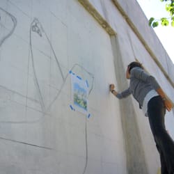 Hubbard Street Murals - Artist Carolina Blanco working on the drawing of her mural depincting a group of Seals, at The Hubbard Street Murals in Chicago