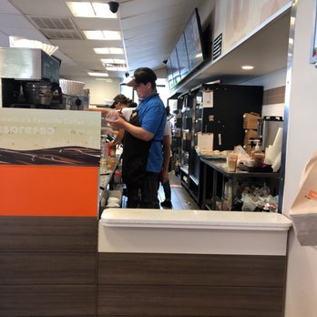 Dunkin' - a man standing at a counter in a restaurant - Donuts Near Me - Rehoboth Beach, Delaware Dunkin' - a man standing at a counter in a restaurant - Donuts Near Me - Rehoboth Beach, Delaware