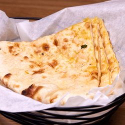 Warm, golden, and kissed by the tandoor -- our Cheese Naan is the kind of bread that makes every bite of curry better.