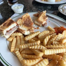 Patty melt with bacon and cheese side of fries served hot