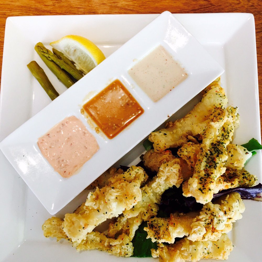 a plate of food with dipping sauces a plate of food with dipping sauces
