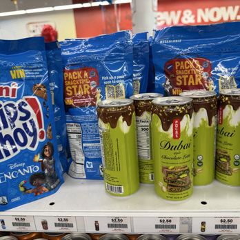 Five Below - Dubai drink?? - The image shows a retail store shelf with multiple cans of Dubai Chocolate Latte and snack bags of Mini Chips Ahoy! cookies. The cans are green with a chocolate drizzle design, and the snack bags are blue with branding and a QR code. Price tags indicating $2.50 are visible along the shelf edge. The background includes store signage and other products. - Discount Store Near Me - Oxnard, California
