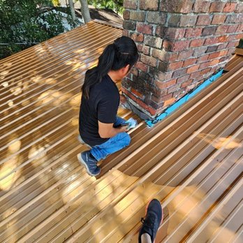 American Roofing - A skilled technician installs and seals new chimney flashing on a metal roof in Winter Haven to prevent future leaks and water damage. - Roofing Near Me - Winter Haven, Florida