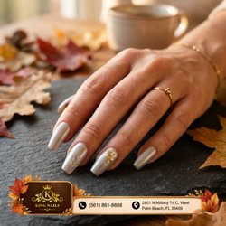 Platinum bride glam! Shimmering silver chrome coffin nails dazzle with fine white leaf art and a radiant floral pearl cluster. Book!