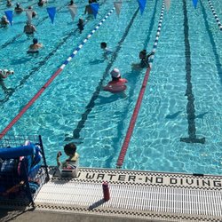 Swim with Heart - Two instructors talking with one child behind them they are not even watching. Neither child are they instructing.