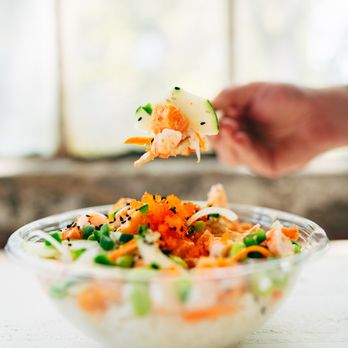 Poke Bros - a person holding a piece of food in a bowl - Hawaiian Near Me - Shorewood, Illinois