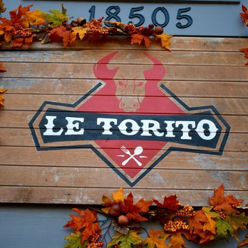 Le Torito - a wooden sign with leaves around it - Mexican Near Me - Clackamas, Oregon