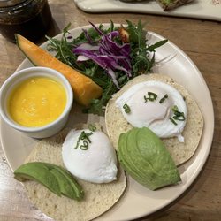 Le Pain Quotidien - Eggs Benedict in front, avocado toast in back.