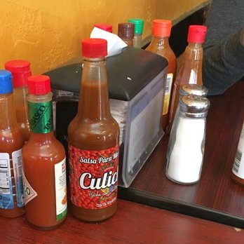 El Zarandeado - a table full of hot sauces and condiments - Mexican Near Me - Albuquerque, New Mexico