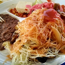 Antojitos Hondureños El Progreso - Carne asada con tajadas. Beef strips on fried green plantains topped with cabbage, pickled veg, refried beans, cheese, chismol.