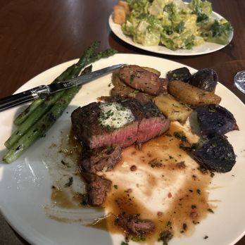 Trattoria Il Mulino - A filet mignon medium finger, potatoes, a Caesar salad and a glass of champagne Caesar Salad* Filet Mignon* - Italian Near Me - Nashville, Tennessee
