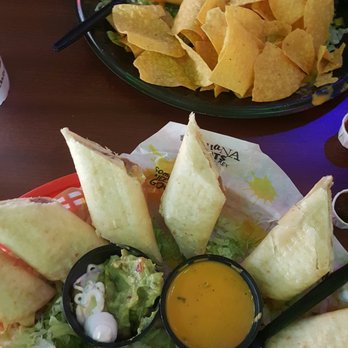 Tijuana Flats - Black bean Chimichanga on top. Refried beans flautas at bottom. - Tex-Mex Near Me - Hollywood, Florida Tijuana Flats - Black bean Chimichanga on top. Refried beans flautas at bottom. - Tex-Mex Near Me - Hollywood, Florida