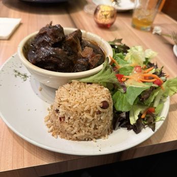Konoko Restaurant - Oxtail, rice and peas, and salad The far side of the photo is jerk chicken and waffles - Caribbean Near Me - White Marsh, Maryland