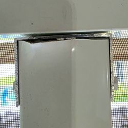 Do It Remodeling - Bent aluminum and poor cut before it was covered with caulk.
