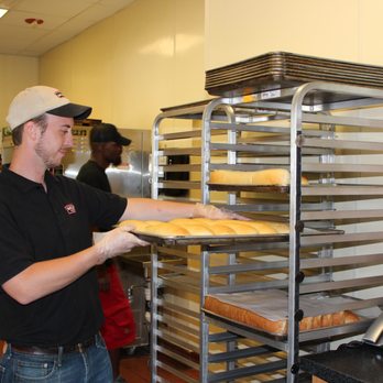 Milio's Sandwiches - a man holding a tray of bread - Sandwiches Near Me - Madison, Wisconsin Milio's Sandwiches - a man holding a tray of bread - Sandwiches Near Me - Madison, Wisconsin