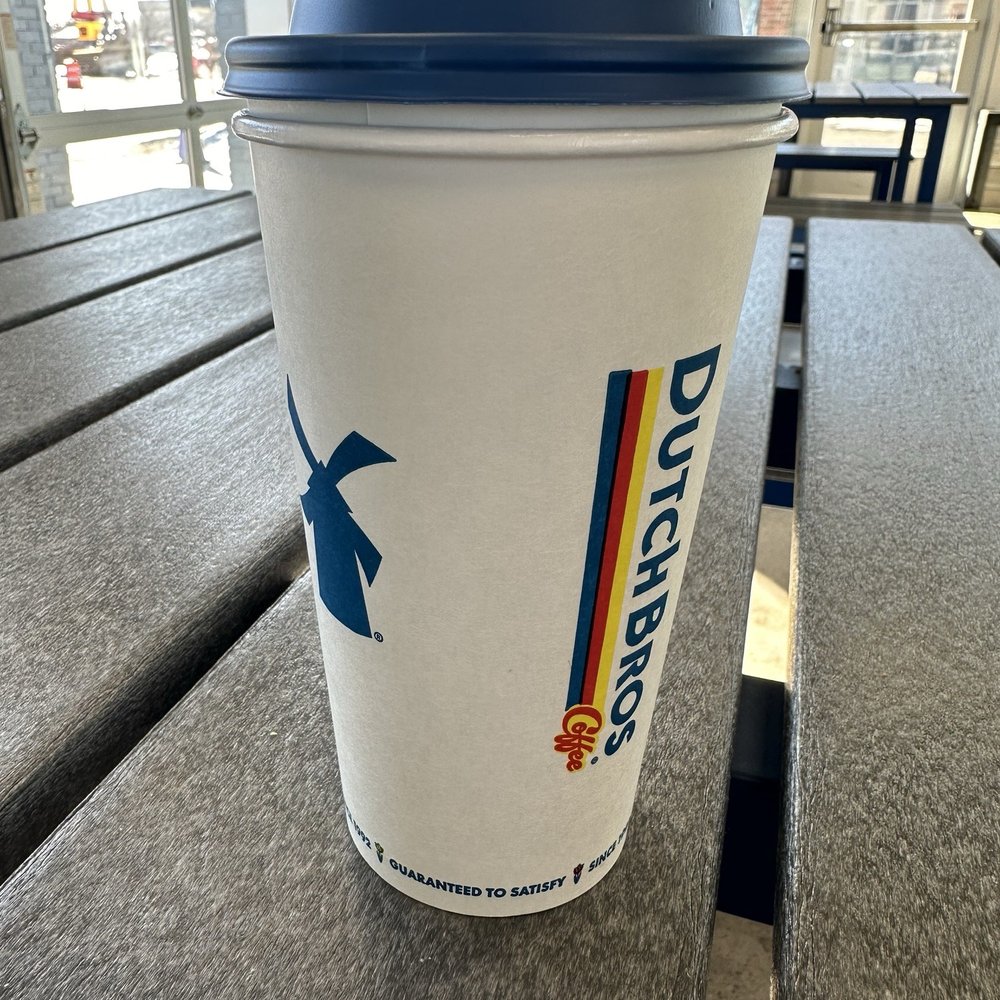 Dutch Bros Coffee - a coffee cup on a bench - Juice Bars & Smoothies Near Me - Wheat Ridge, Colorado Dutch Bros Coffee - a coffee cup on a bench - Juice Bars & Smoothies Near Me - Wheat Ridge, Colorado