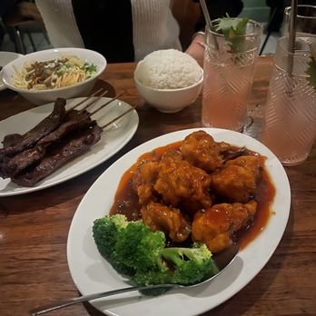 Blossom Bar - General Tso Chicken (front and center), White Rice (far center), Teriyaki Skewers (left), and Dan Dan noodles (far left). - Cocktail Bars Near Me - Brookline, Massachusetts
