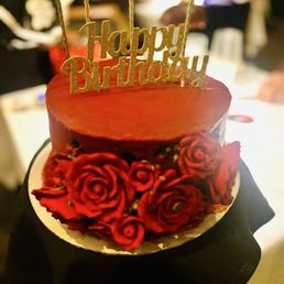Dark Chocolate cake w/ white frosting between layers. Red buttercream frosting, red roses w/ metallic gold stamen. Dark Chocolate cake w/ white frosting between layers. Red buttercream frosting, red roses w/ metallic gold stamen.