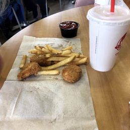 a chicken sandwich with fries and a drink