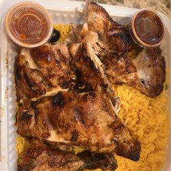 Half bbq chicken combo with yellow rice, barbecue sauce, and hot sauce