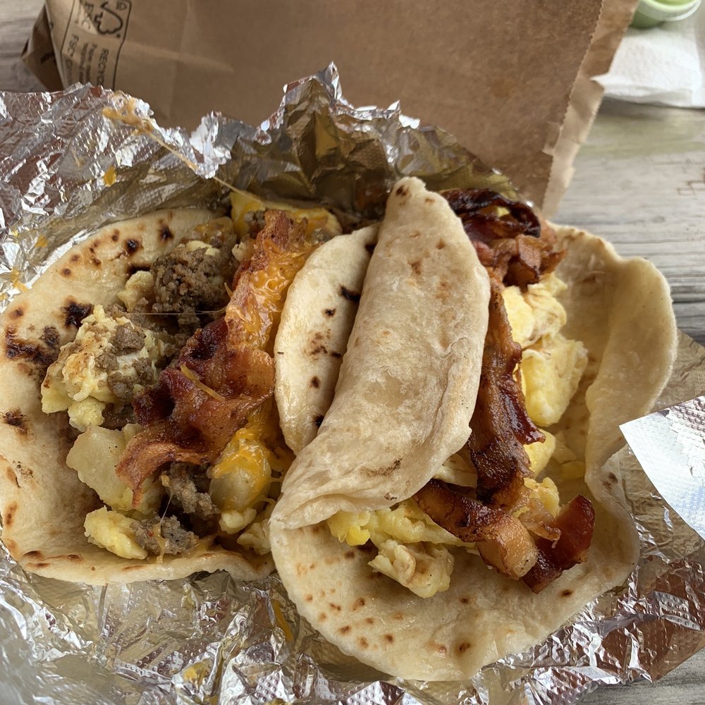 a close up of a taco with bacon and eggs