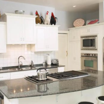 Davic Construction - a kitchen with white cabinets and black countertops - General Contractors Near Me Davic Construction - a kitchen with white cabinets and black countertops - General Contractors Near Me
