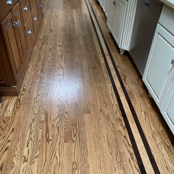 Unique Hardwood Floors - a kitchen with white cabinets - Refinishing Services Near Me Unique Hardwood Floors - a kitchen with white cabinets - Refinishing Services Near Me