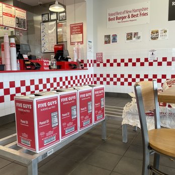 Five Guys - a table and chairs in a fast food restaurant - Burgers Near Me - Selden, New York