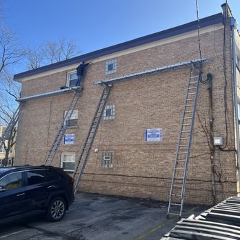 Enriquez Gutter - Ladders setup to paint gutter soffits - Gutter Services Near Me - Chicago, Illinois