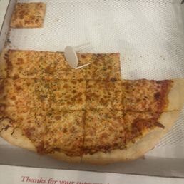 Cheese Pizza - A cheese pizza with a few slices missing is inside a pizza box, with a small slice remaining and a plastic pizza saver.