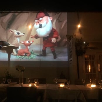 Alexanders on 30th - Rudolph the Red-Nosed Reindeer playing on a projector - Italian Near Me - San Diego, California
