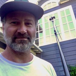 Redwood Window Cleaning - The owner, Brent Bandi, cleans a tall exterior window
