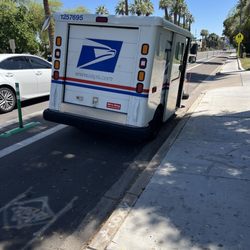 US Post Office - Post office delivery vehicle parked in separated bike lane (they drive between the barriers)