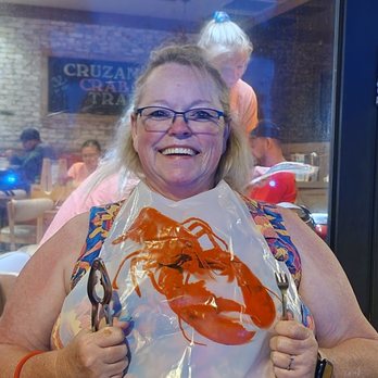 Crabby's Oceanside - Iva with her crab crackers, Fork and bib - Seafood Near Me - Daytona Beach, Florida