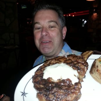 Saltgrass Steak House - I wanted to see how big the 24oz rib eye looked compared to someone head....this joker ordered the chicken.  Chicken???? - Steakhouses Near Me - Irving, Texas