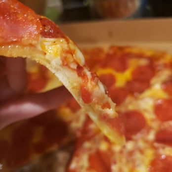 Cappy's Pizza - a hand holding a slice of pepperoni pizza - Italian Near Me - Riverview, Florida