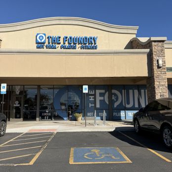 The Foundry - The Foundry fitness studio storefront features signage for hot yoga, Pilates, and fitness, with accessible parking spaces and a clear view of the building exterior. - Yoga Near Me - Avondale, Arizona