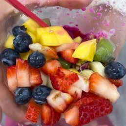 a person holding a bowl of fruit