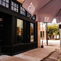 The Riot - The Riot Café & Bar on Washington Avenue in Houston features a brick exterior, black window frames, a bright neon sign, and b...