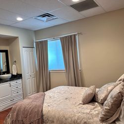 Intimate Journey Birth & Wellness Center - Lotus birthing room with birth tub, sink, private bathroom and queen bed
