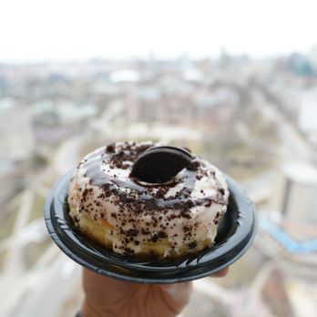 Dipped - a hand holding a donut with chocolate sprinkles - Donuts Near Me - Toronto, Ontario