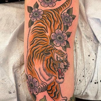 Golden Reaper Tattoo - Traditional tiger! I requested some flowers for female flair too! Love it! Approximately 7"x3" space took her under 3 hours. Beautiful! - Tattoo Near Me Golden Reaper Tattoo - Traditional tiger! I requested some flowers for female flair too! Love it! Approximately 7"x3" space took her under 3 hours. Beautiful! - Tattoo Near Me