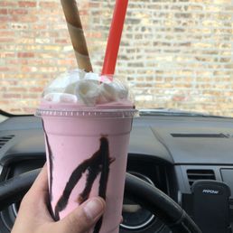 a hand holding a cup of milkshake