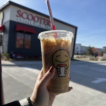Scooter's Coffee - a hand holding a cup of iced coffee - Coffee & Tea Near Me - Wilmington, North Carolina Scooter's Coffee - a hand holding a cup of iced coffee - Coffee & Tea Near Me - Wilmington, North Carolina